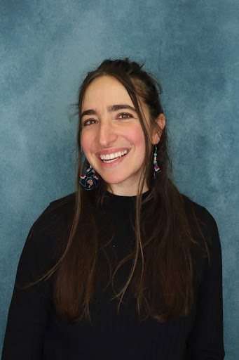 Portrait of Ren Langer smiling against a blue backdrop