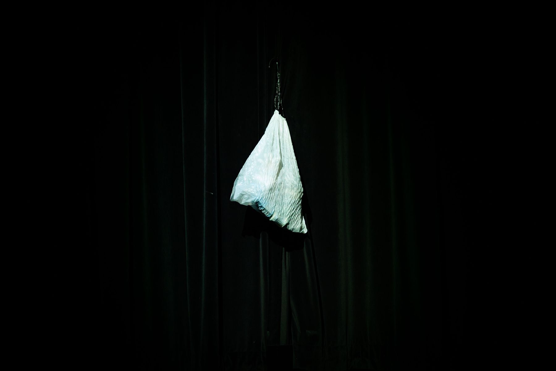 A plastic bag hangs in a pool of light