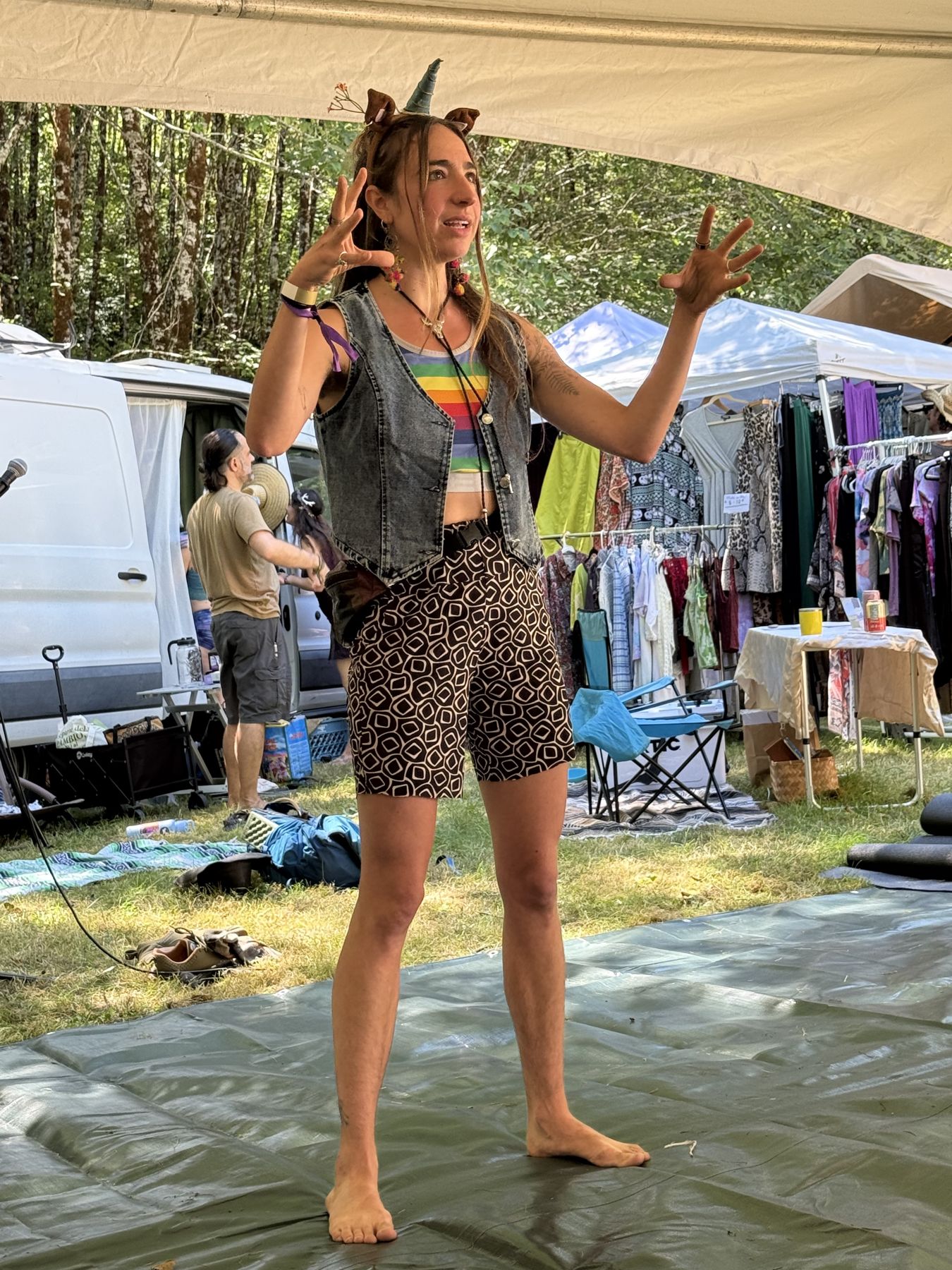 A facilitator gestures mid-sentence under a festival tent