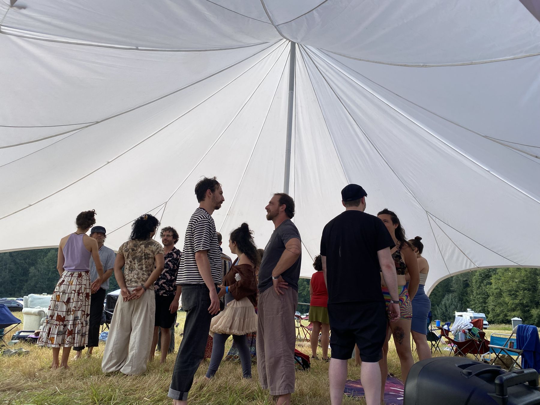 A group standing in a circle under a canopy